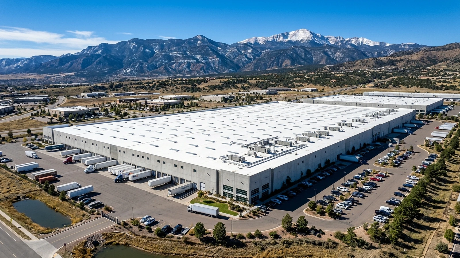 Aerial view of an industrial flat-roof warehouse in Colorado Springs with skylights and solar array mounts